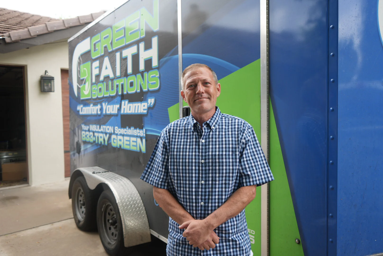 A Green Faith Solutions franchise owner standing beside a company trailer