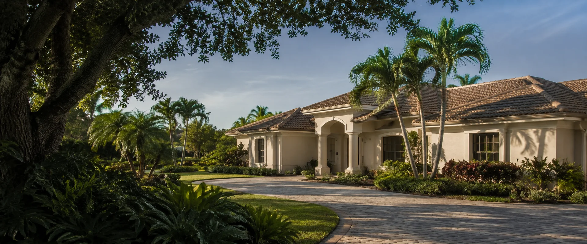 Illustrative South Florida home with a tile roof, palms, and lush tropical landscaping